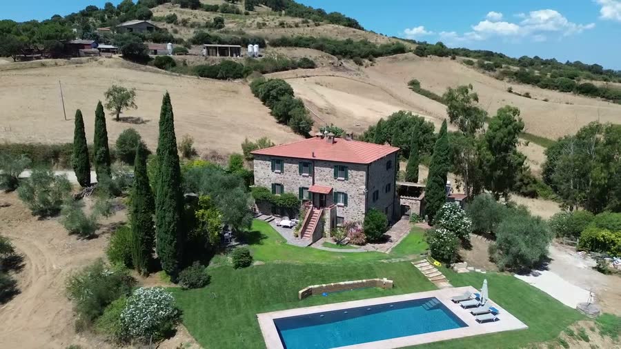 Aerial view of the house and pool among cypresses and open countryside