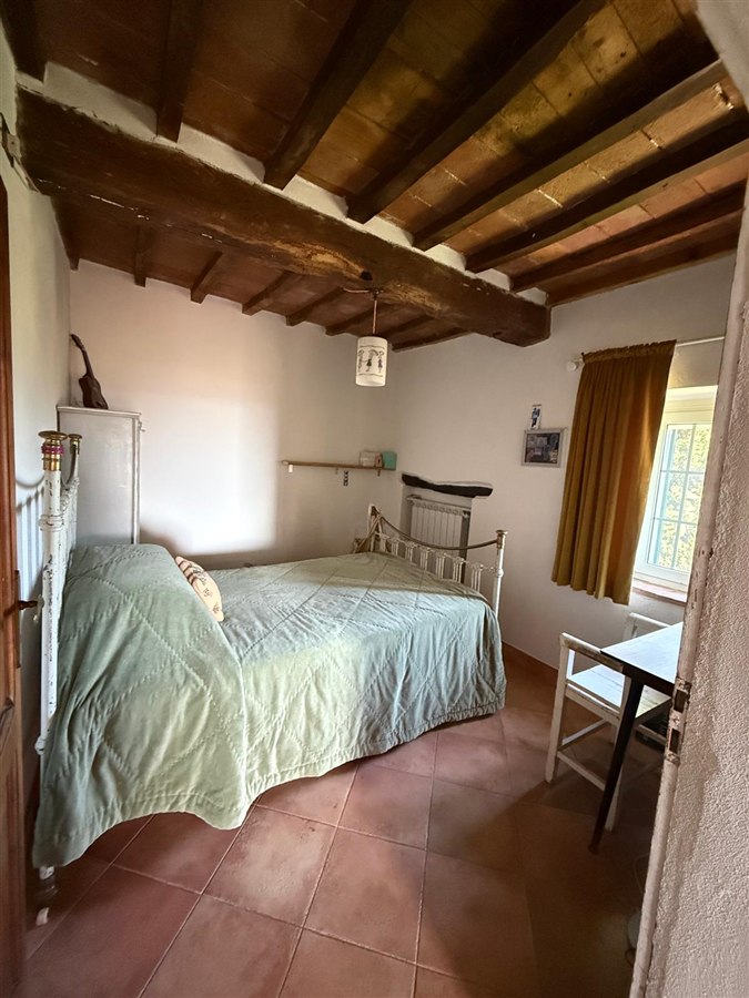 Double bedroom with an antique iron bed and exposed timber ceiling