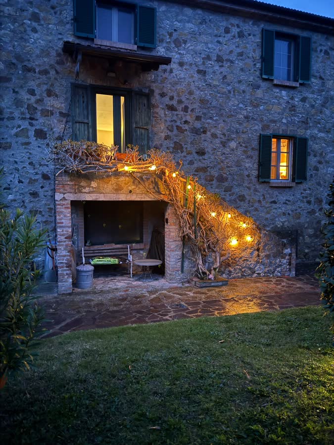 The sheltered seating area beneath the outside staircase, with lights along the vine above it