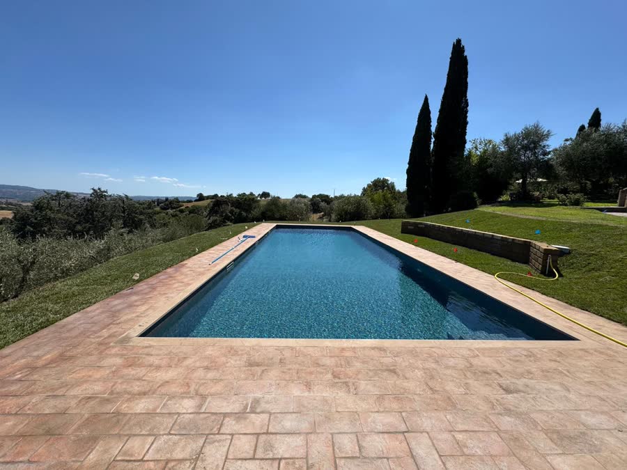 The saltwater pool with olive trees and open countryside beyond