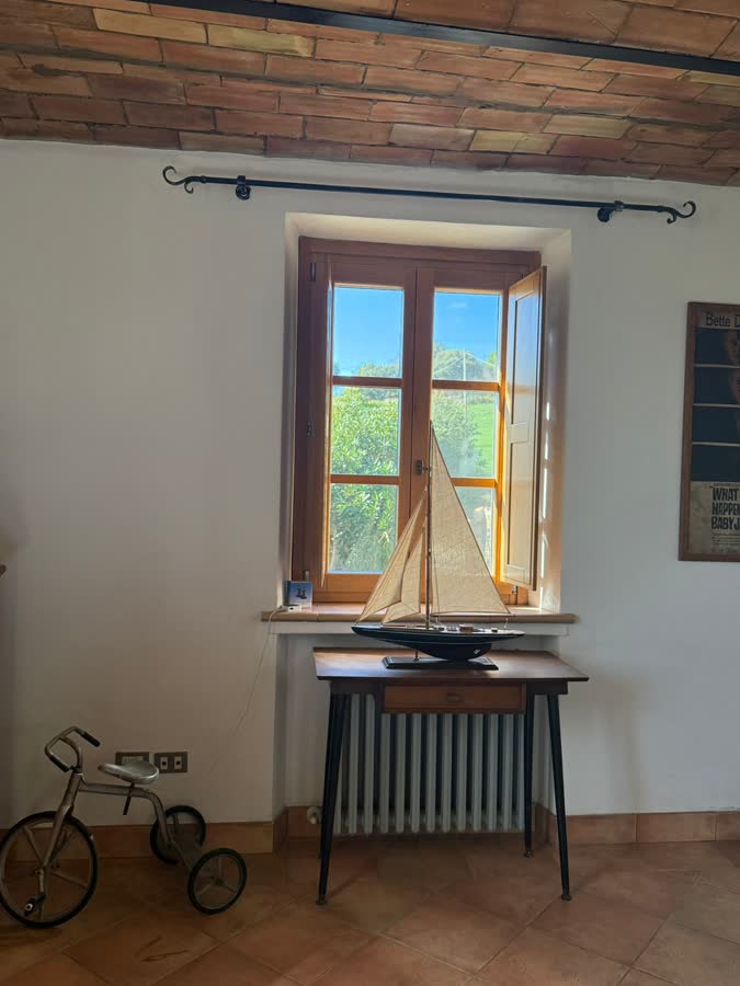 A model sailing boat on a table beneath an open window